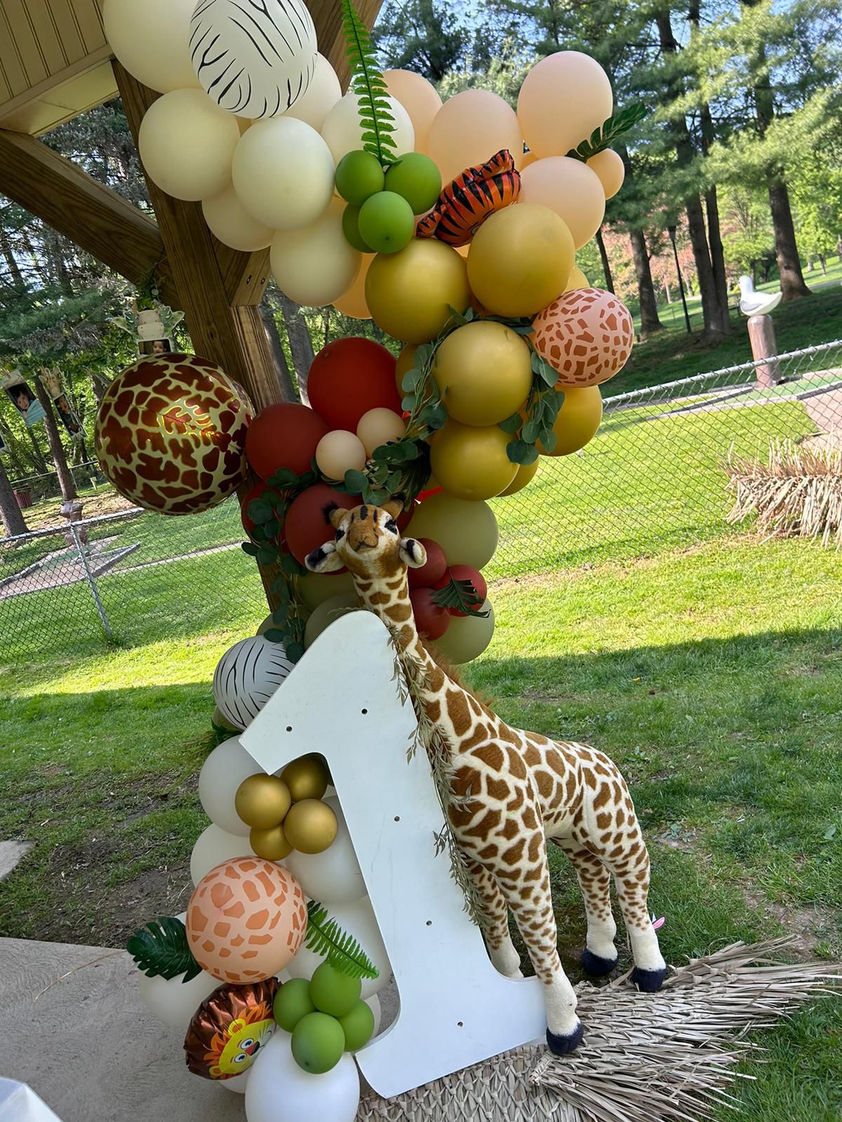 Decoración de primer cumpleaños con globos en tonos naturales y detalles de safari