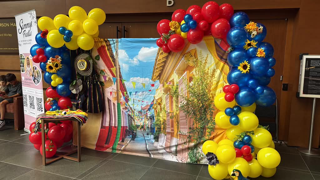 Arco de globos amarillo, azul y rojo con detalles culturales colombianos, creado por Sammy’s Fiestas